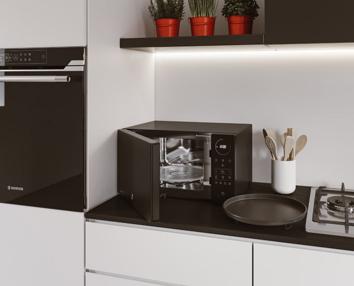 How does the microwave oven’s defrosting function work?